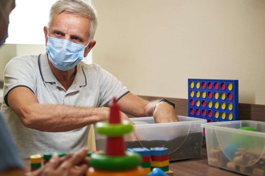 Photo of ergotherapy with stroke man in rehab center